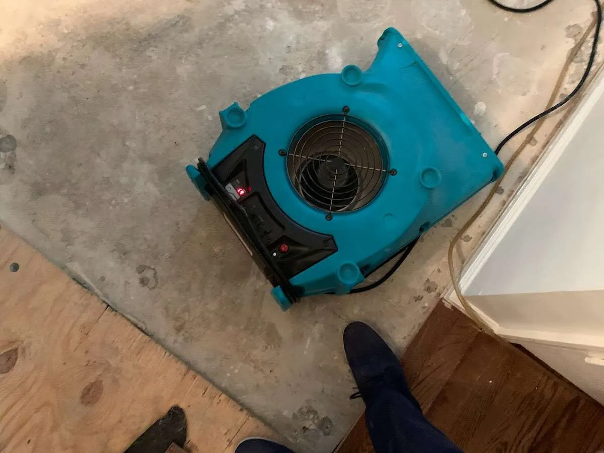 Air mover drying subfloor during Leak Detection & Repair in Suffield